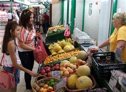 マリア・レシノバちゃん（左）と母・スネジャさんは、市場でおやつのヨーグルトを購入後、一緒に食べる果物も買った　＝ブルガリア・ソフィア市内
